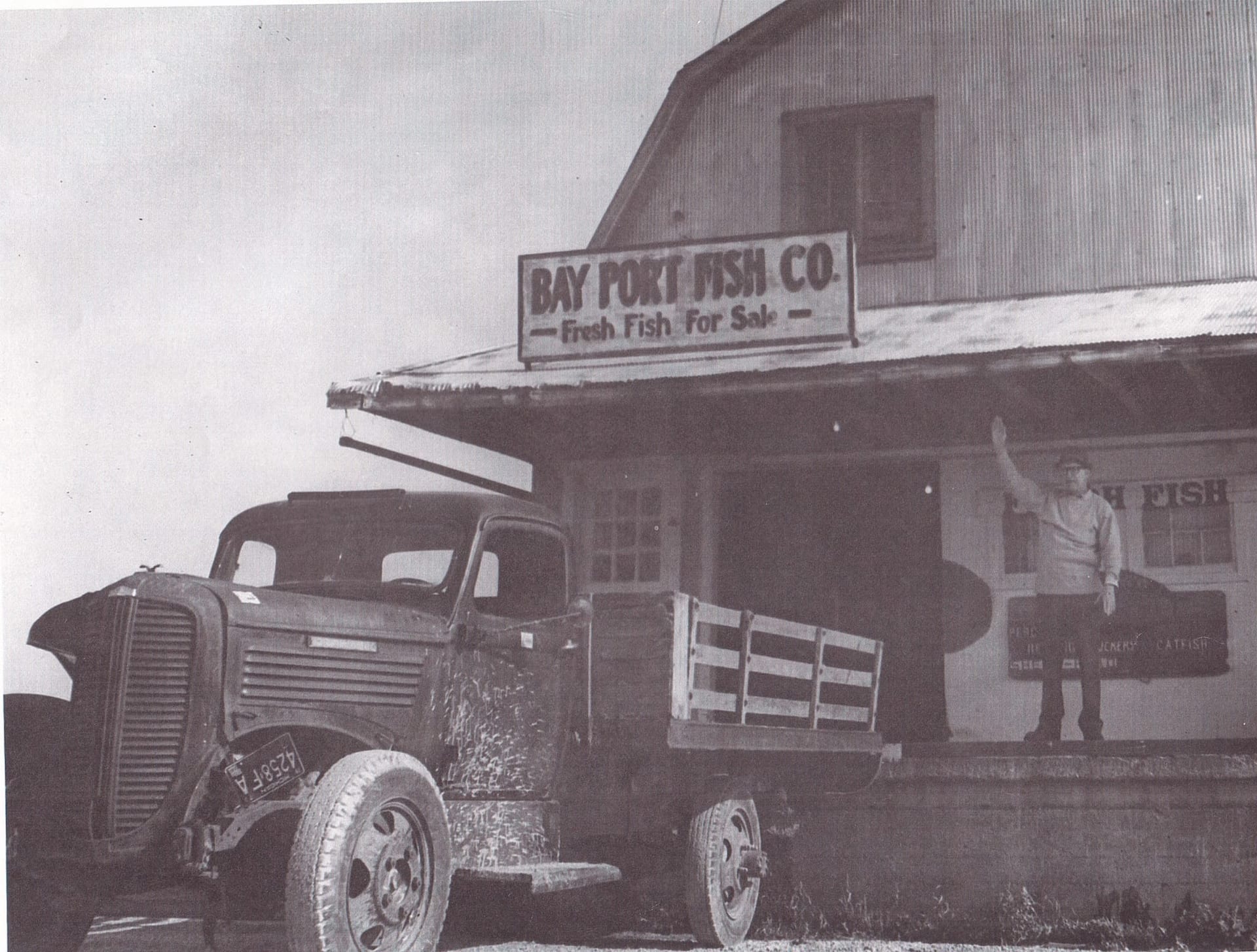 Previous Owner Henry Engelhard waves to customers from the porch of the fishery, 1950s.